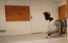 a person squatting down in front of a door with a few electrical outlets