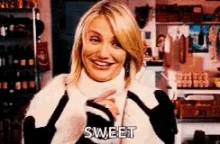 a woman in a black and white sweater is smiling and saying sweet