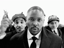 a man in a suit and tie stands in a crowd