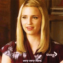 a blonde woman is sitting on a couch and says very very hard