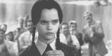 a black and white photo of a girl with pigtails in front of a crowd .