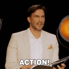 a man in a suit is holding a clipboard with the word action written on it