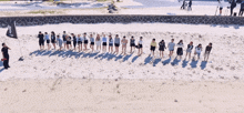 a large group of people are running on a beach with a flag that says ' a ' on it
