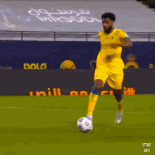 a man in a yellow jersey is kicking a soccer ball on the field