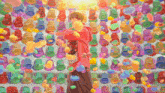 a man in a red hoodie stands in front of a wall of colorful gummy bears