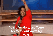 a woman in a red dress is holding a microphone and saying " you 're my mess and you 're my mess "