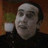 a man with white paint on his face is making a funny face with his mouth open