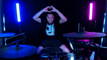 a man with a tattoo on his arm is playing drums and giving a thumbs up