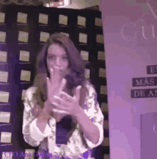 a woman is standing in front of a sign that says el mas de an