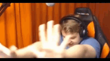 a man wearing headphones is sitting in a chair giving a high five .