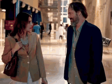 a man and a woman are standing next to each other in a hospital hallway