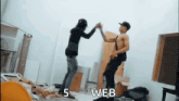 two men are giving each other a high five in a room with the number 5 on the wall .