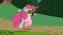 a pink pony is wearing a pair of hypnotic glasses and holding an arrow in its mouth