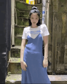 a girl wearing a blue dress and a white t-shirt with candy cane written on it
