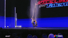 a man and a woman are dancing in front of a blue background that says nbc on it