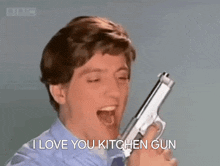 a man is holding a gun in his hand and screaming .