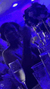 a woman sits at a table with a glass of champagne in front of her