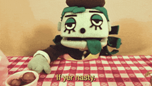 a stuffed animal is sitting on a checkered tablecloth and says if yer nasty
