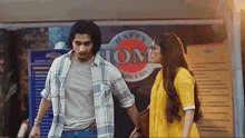 a man and a woman are standing in front of a restaurant .
