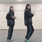 two women are standing next to each other in a room