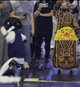 a man in a costume with a face on it is dancing in front of a crowd