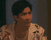 a man in a black tank top is looking at the camera and making a funny face .