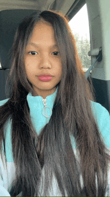 a girl with long hair is wearing a blue and white jacket