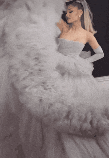 a woman in a white dress and gloves is looking at herself in the mirror