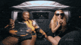 two women are sitting in the back seat of a car with the word zeus on the bottom