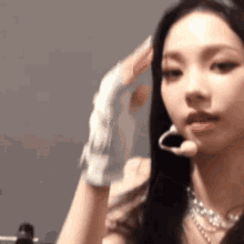 a close up of a woman wearing a glove and earrings .