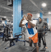 a man in a blue and white shirt is standing in a gym with a woman watching