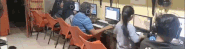 a group of people are sitting in front of computers .