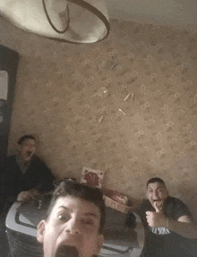 two men are giving a thumbs up in front of a wall clock that says xii