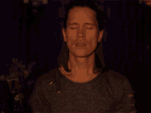 a man with his eyes closed is wearing a ripped shirt