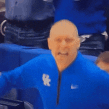 a man wearing a blue nike jacket with the letter x on the front