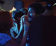 a man and a woman are kissing in front of a string of lights