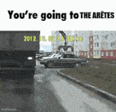 a car is driving down a street next to a dumpster that says you 're going to the arette