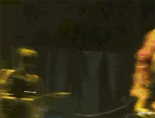 a man in a red and white striped shirt is standing on a stage with his arms in the air ..