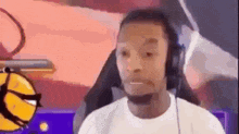 a man wearing headphones is sitting in a chair in front of a basketball .