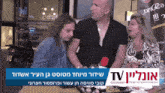a group of people are sitting in front of a sign that says ' tv '