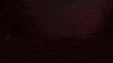 a cross is lit up in a dark room with a red background