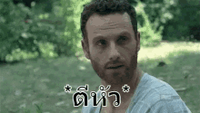 a man with a beard and a foreign language on his face is looking at the camera .