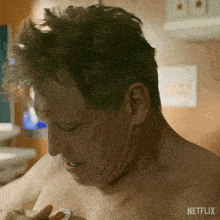 a shirtless man is holding a coin in his hand and a netflix logo is visible in the corner