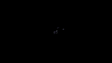 a blurred image of a person walking in a dark room with a light behind them