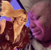 a woman with long blonde hair is standing next to a man with a crying face