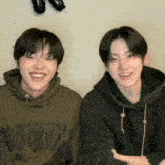 two young men wearing hoodies one of which has the word hoodie on the front