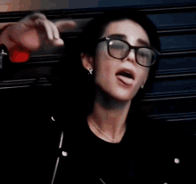 a close up of a person wearing glasses and a black shirt