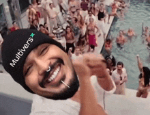 a man wearing a beanie with the word multivers on it is taking a selfie