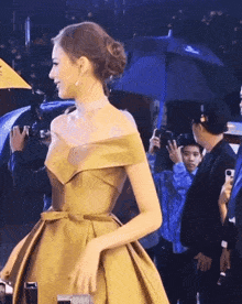 a woman in a gold dress is being photographed