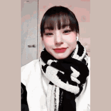 a woman wearing a black and white scarf with the letter t on it